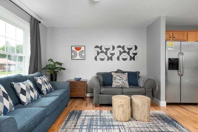 living room with light wood-type flooring and baseboard heating