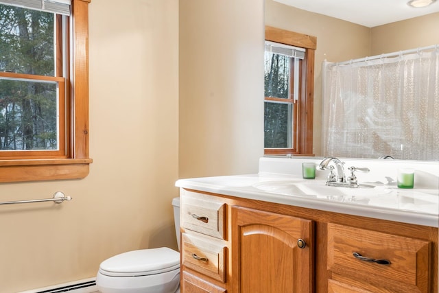 bathroom with toilet, vanity, and baseboard heating