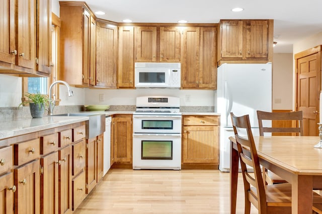 kitchen featuring sink, white appliances, and light hardwood / wood-style floors