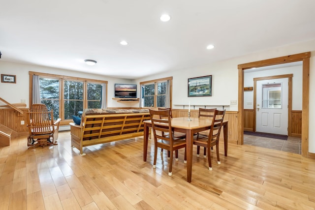 dining room featuring wooden walls and light hardwood / wood-style flooring