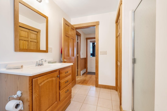 bathroom featuring a baseboard heating unit, walk in shower, tile patterned floors, and vanity