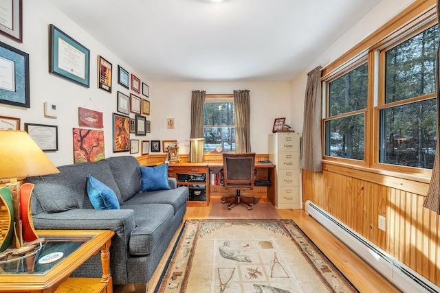 office space with baseboard heating, wooden walls, and hardwood / wood-style flooring