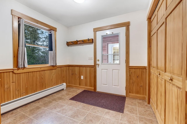 entryway with baseboard heating and wooden walls