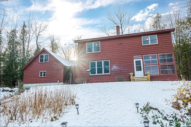 view of snow covered back of property