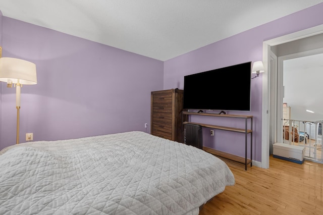 bedroom featuring radiator and light hardwood / wood-style flooring