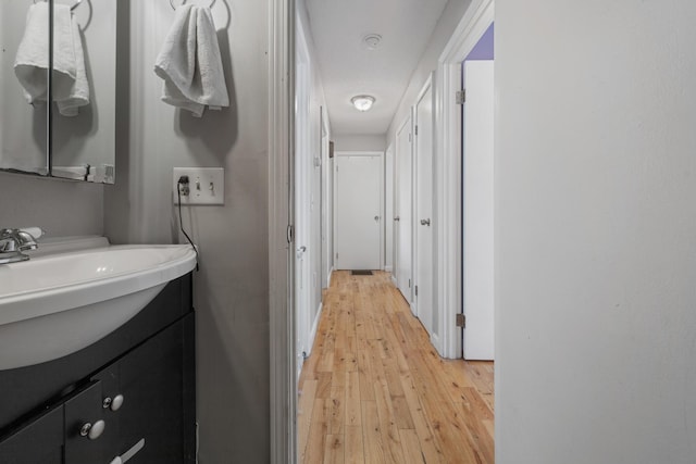 hall with sink and light hardwood / wood-style floors