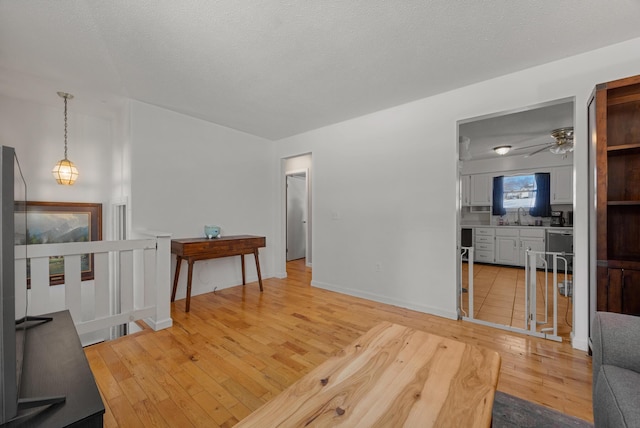 interior space featuring sink, light wood-type flooring, and a textured ceiling