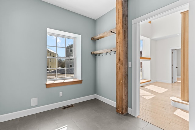 unfurnished room featuring baseboards and visible vents