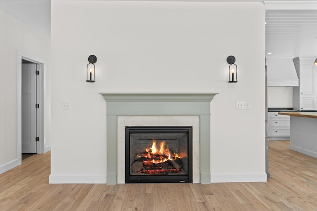 details featuring baseboards, wood finished floors, and a tile fireplace