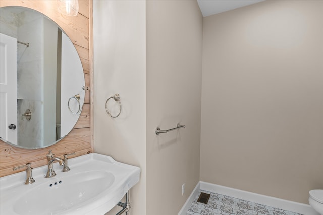 bathroom with baseboards, a sink, and toilet