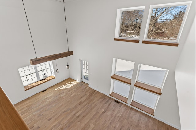 interior space featuring light wood-style flooring, visible vents, and baseboards