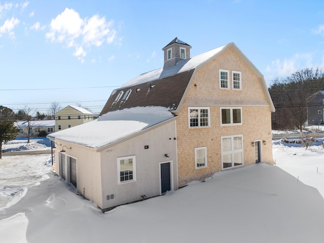 snow covered house with a gambrel roof