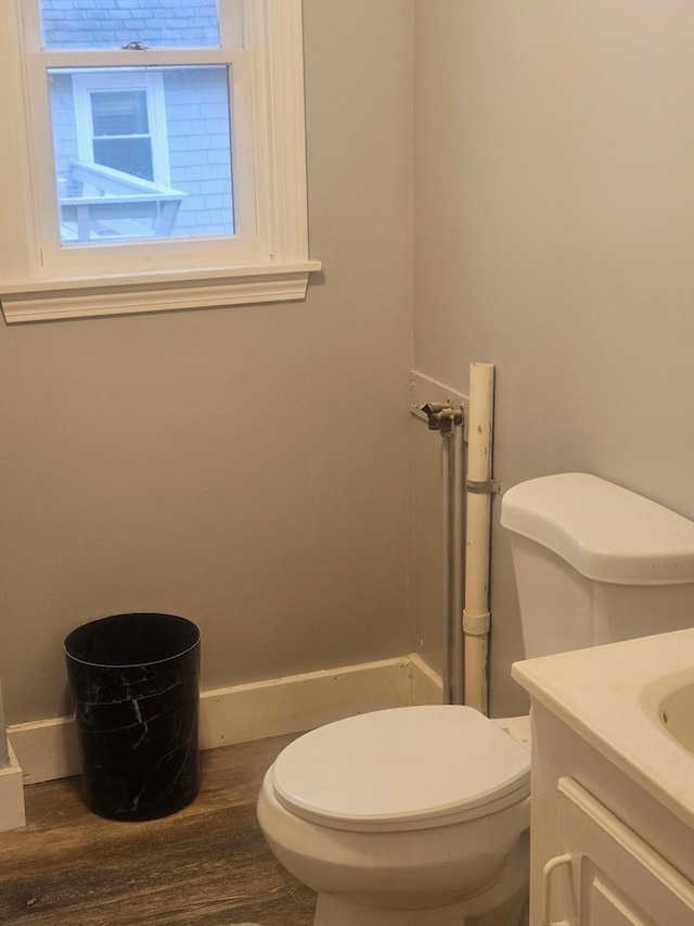 bathroom featuring wood-type flooring, vanity, and toilet