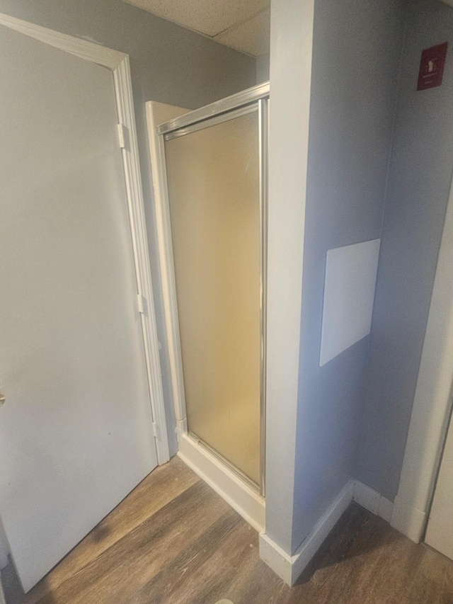 bathroom featuring hardwood / wood-style floors and a shower with shower door