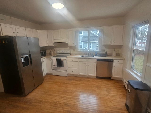 kitchen featuring light hardwood / wood-style floors, white cabinets, a healthy amount of sunlight, and appliances with stainless steel finishes