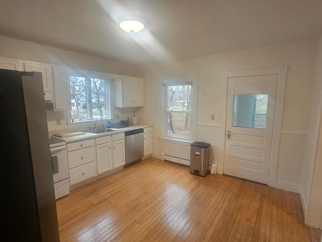 kitchen featuring white cabinets, light wood-type flooring, sink, and appliances with stainless steel finishes