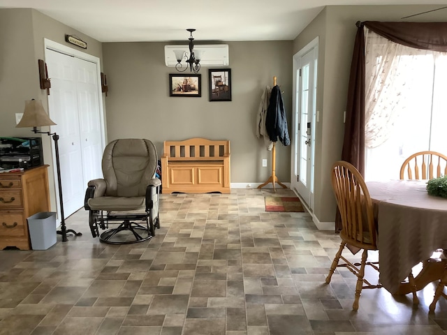 sitting room featuring a chandelier and a wall mounted air conditioner