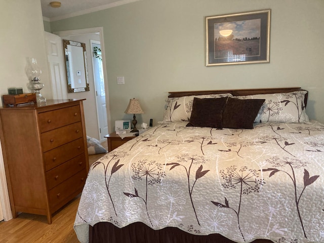 bedroom with light wood-type flooring and ornamental molding