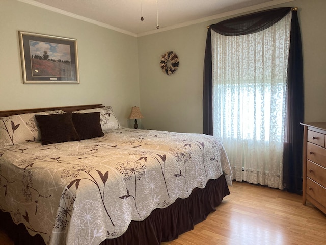 bedroom with crown molding and light hardwood / wood-style flooring