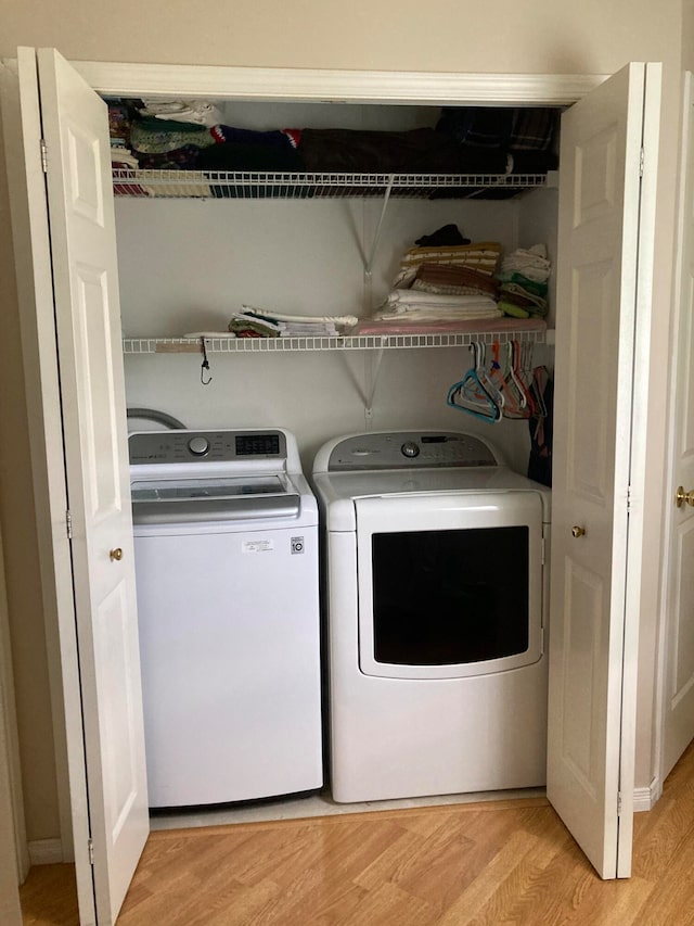 laundry area featuring light hardwood / wood-style floors and separate washer and dryer