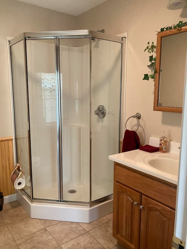 bathroom featuring tile patterned floors, vanity, and a shower with shower door