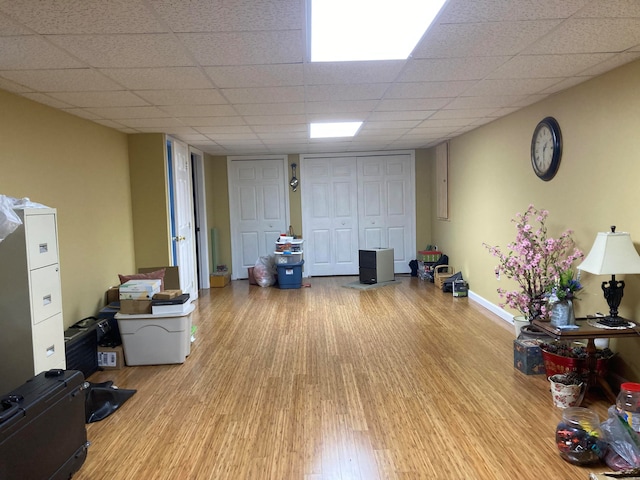 interior space featuring a paneled ceiling and light hardwood / wood-style floors