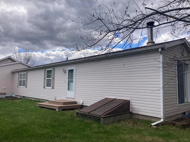 rear view of house with a lawn and a wooden deck