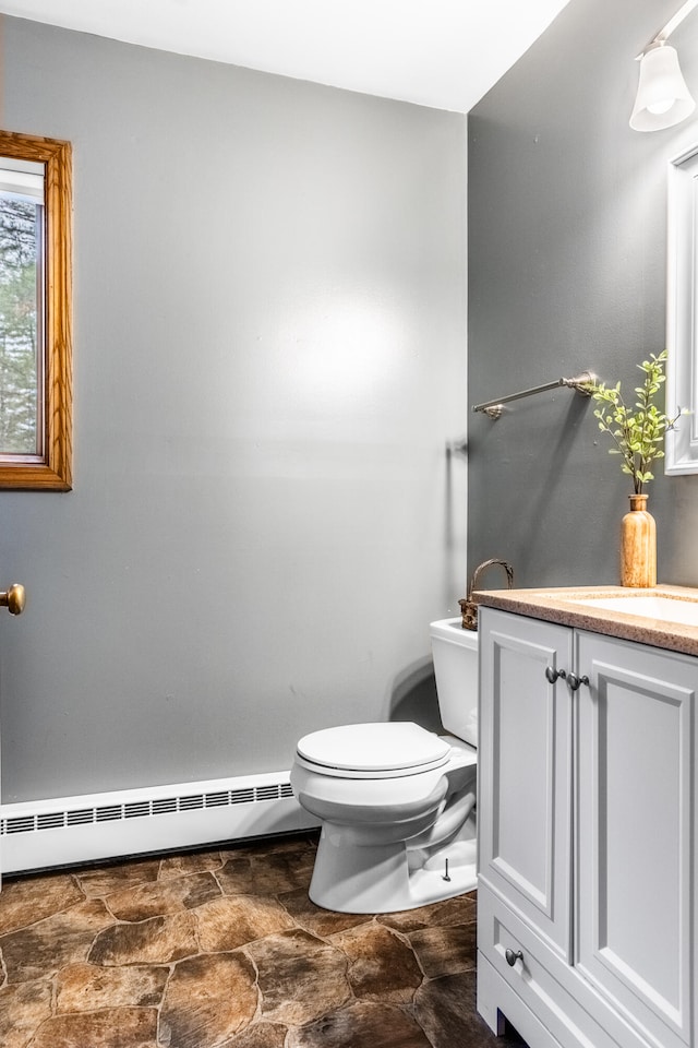 bathroom with vanity, a baseboard radiator, and toilet