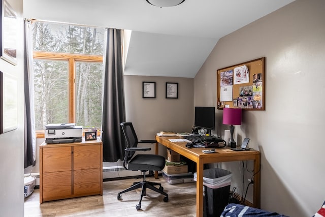 home office with light hardwood / wood-style floors and lofted ceiling