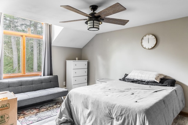 bedroom with hardwood / wood-style flooring, vaulted ceiling, and ceiling fan