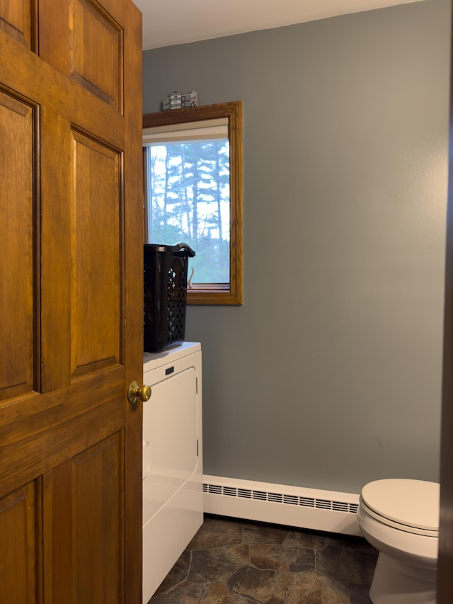 washroom with dark tile patterned flooring and a baseboard heating unit