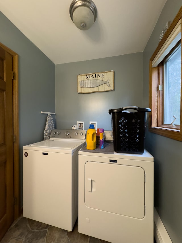 washroom with dark tile patterned floors and washer and clothes dryer