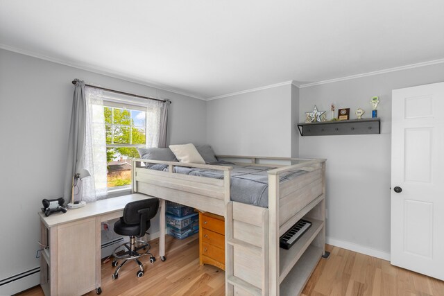 bedroom with ornamental molding, light hardwood / wood-style flooring, and a baseboard heating unit