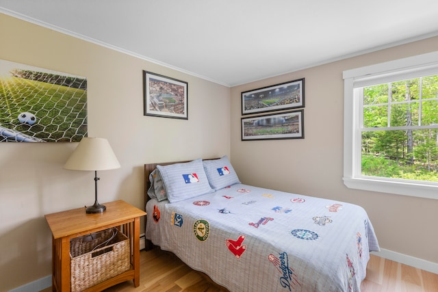 bedroom featuring light hardwood / wood-style flooring and ornamental molding