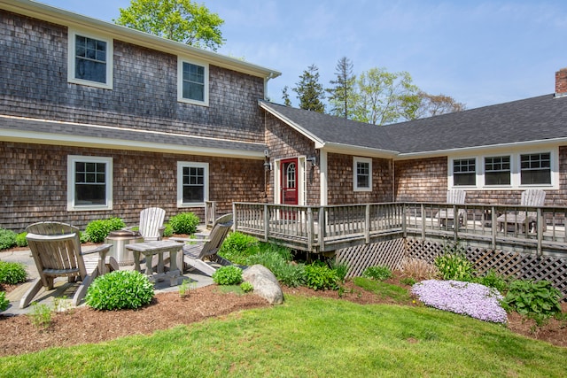 view of front of home featuring a wooden deck and a front lawn