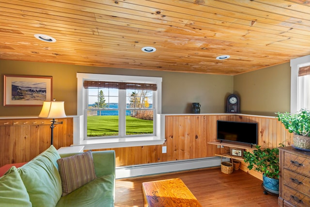living room featuring light hardwood / wood-style floors, wood ceiling, and a baseboard heating unit