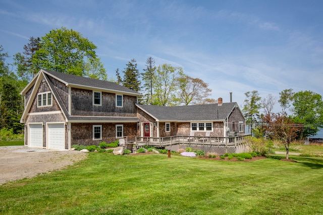 view of front of home with a wooden deck, a front lawn, and a garage