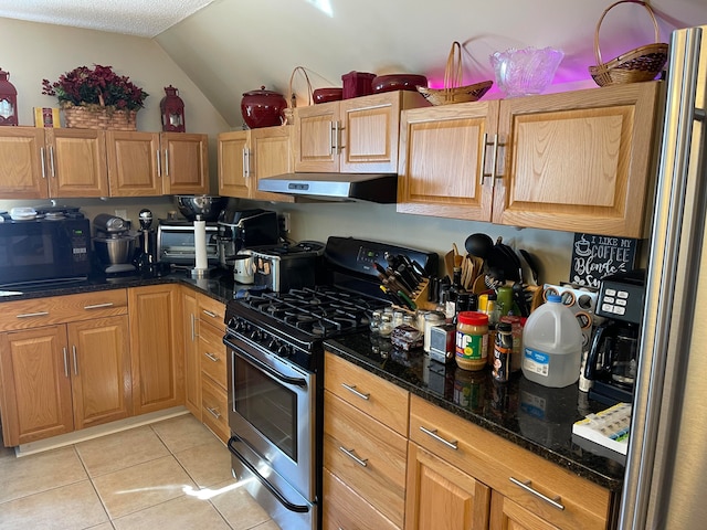 kitchen with stainless steel appliances, dark stone countertops, vaulted ceiling, light tile patterned flooring, and exhaust hood