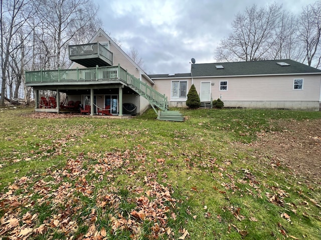 rear view of property featuring a lawn and a wooden deck