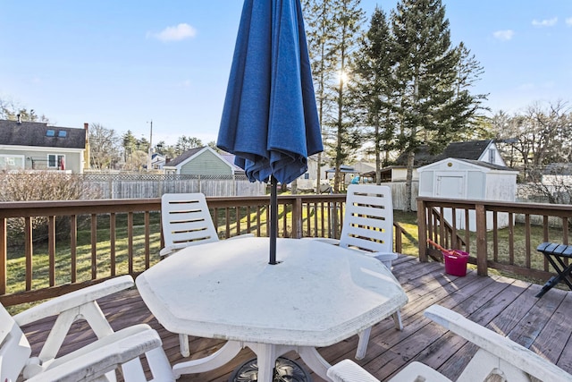 wooden deck featuring a lawn and a storage shed