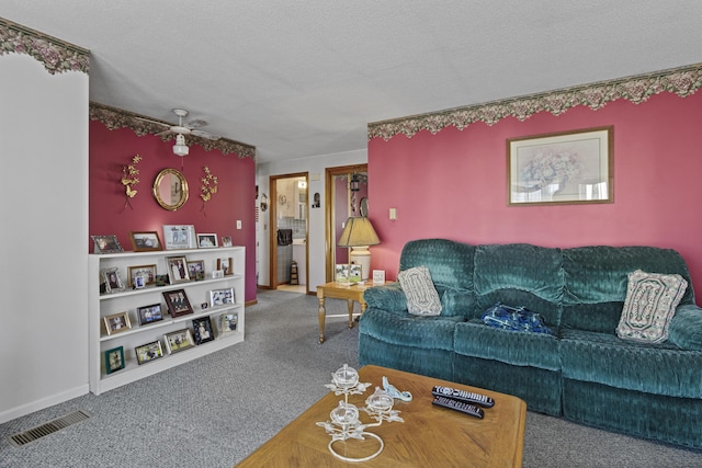 living room featuring carpet flooring, a textured ceiling, and ceiling fan