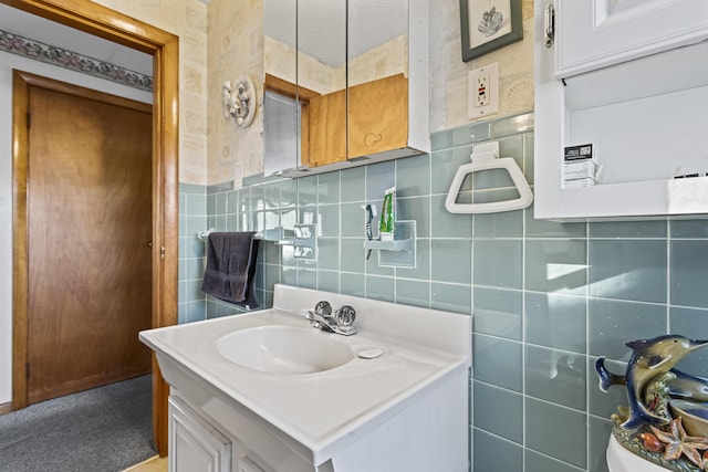 bathroom featuring a textured ceiling, vanity, and tile walls