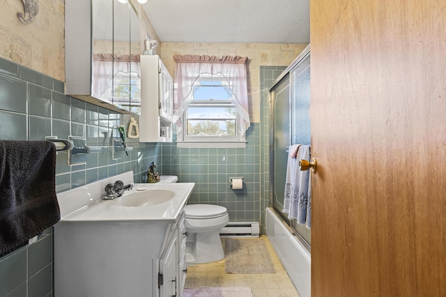 full bathroom with vanity, tile patterned flooring, tile walls, a textured ceiling, and a baseboard radiator