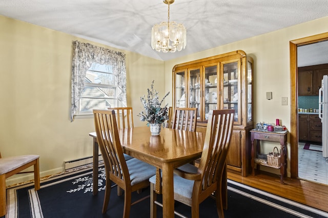 dining room featuring baseboard heating, hardwood / wood-style floors, a textured ceiling, and a notable chandelier