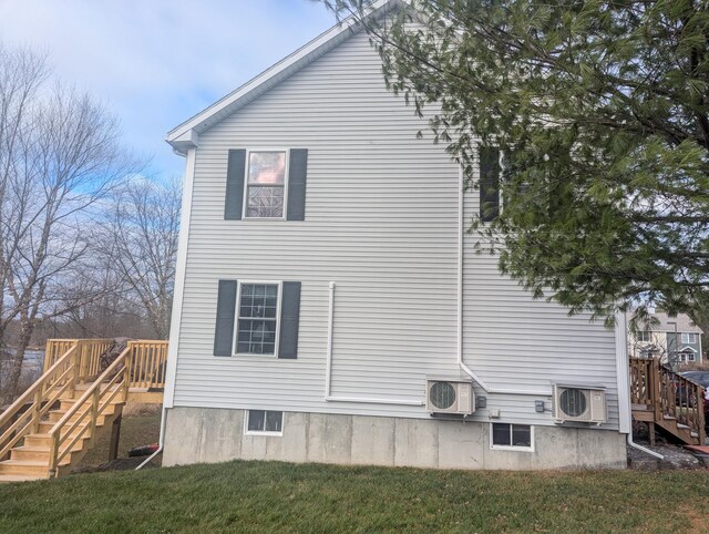 view of side of home featuring ac unit, a deck, and a lawn