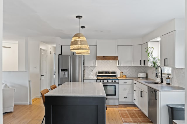 kitchen featuring a center island, light wood-type flooring, sink, and appliances with stainless steel finishes