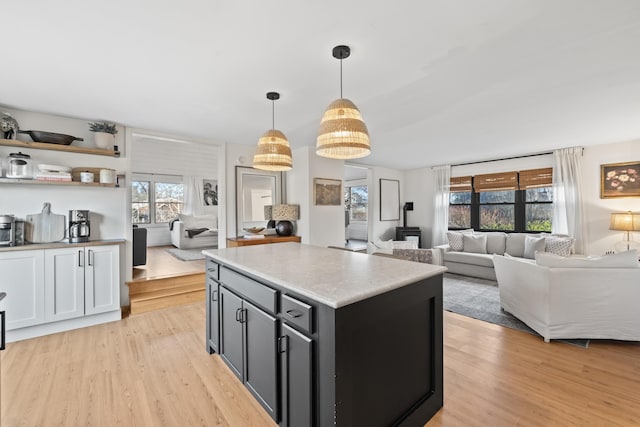 kitchen featuring pendant lighting, a kitchen island, and light wood-type flooring