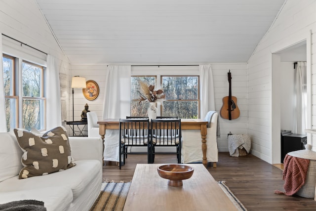 living room featuring dark hardwood / wood-style floors, vaulted ceiling, and wooden walls