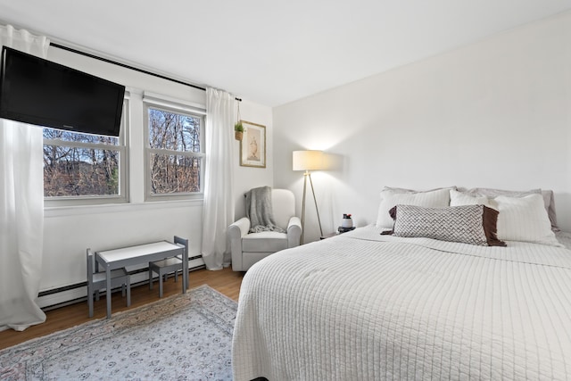 bedroom featuring hardwood / wood-style floors and baseboard heating