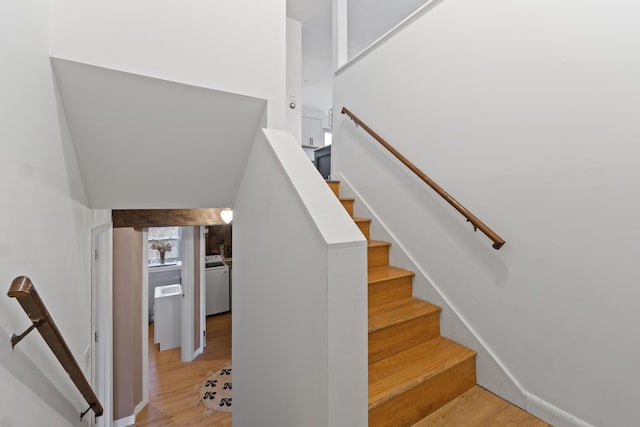 staircase featuring washer / dryer and wood-type flooring